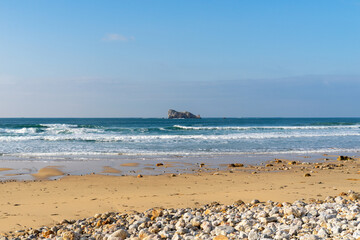 La plage de Pen Hat mêle harmonieusement galets et sable, offrant une vue imprenable sur le rocher du Lion, symbole de la beauté naturelle de la région.