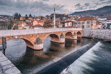 A picturesque scene of Sehercehaja Bridge spanning the river in Sarajevo, Bosnia