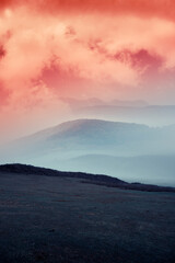 colorful simple landscape with hills in fog