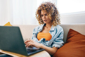 Smiling Woman Using Laptop in Cozy Living Room