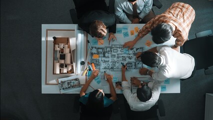 Top aerial view of project manager or civil engineer writing at blueprint and planning building design. Aerial view of architect working together at meeting table with document placed. Alimentation.