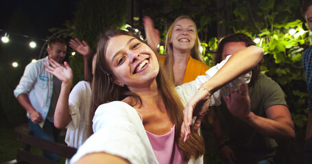 POV of joyful Caucasian girl talking to camera. Pretty African American and Asian girls waving...