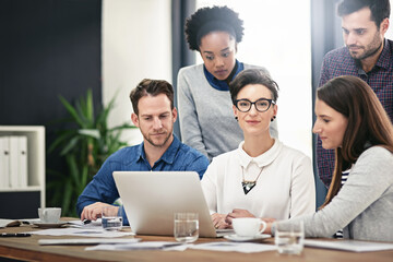 Laptop, meeting and project management with designer business people in office for creative discussion. Computer, design and small business startup with employee group in workplace for teamwork