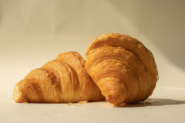 freshly baked croissants in a colored background, green, black, or neutral. with fresh flowers newspaper, cappuccino showing layers and crumbles and filling with berries