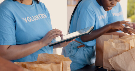 People volunteering, tablet and food donation in community service, poverty support and NGO checklist. Nonprofit, hands or group packaging groceries, planning package or helping for charity project