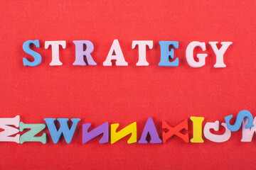 STRATEGY word on red background composed from colorful abc alphabet block wooden letters, copy...