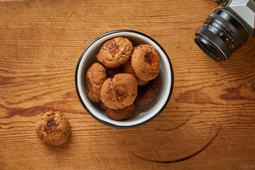 A bowl with seed cookies on a table with a camera