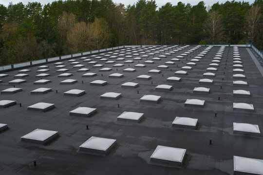 Top view of a modern roof with natural light. Skylights. Energy efficiency. Transparent panels on the roof.