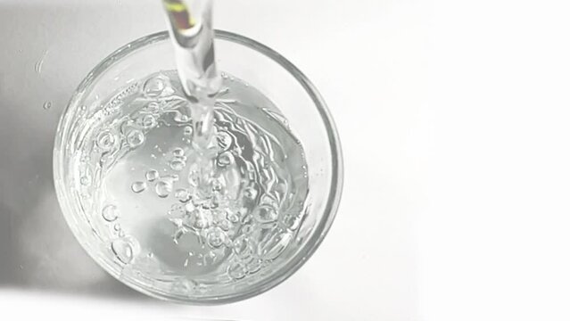 slow motion shot of pouring water into glass, drinking water in glass top view, closeup of water 