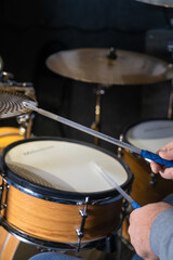 Close-up of drumsticks on drums in the hands of a drummer, selective focus. Vertical photo