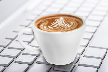 A cup of tasty aroma hot cappuccino at work place