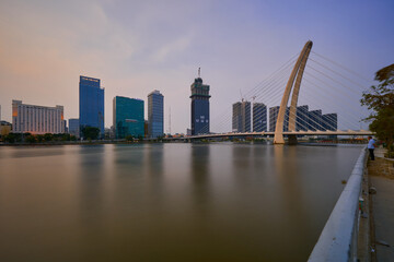 Naklejka premium Ho Chi Minh City skyline and the Saigon River. Amazing colorful night view of skyscraper and other modern buildings at downtown. Travel concept