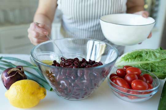 Woman preparing a fresh beans salad in the kitchen