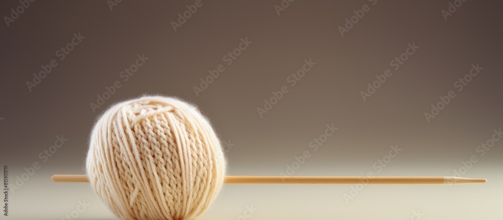 Poster a close up image shows knitting needles piercing a ball of beige yarn for knitting on a light backgr