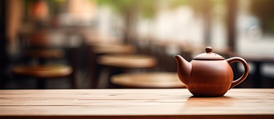 Copy space image of a close up tea pot resting on a wooden table in a Cafe - Powered by Adobe