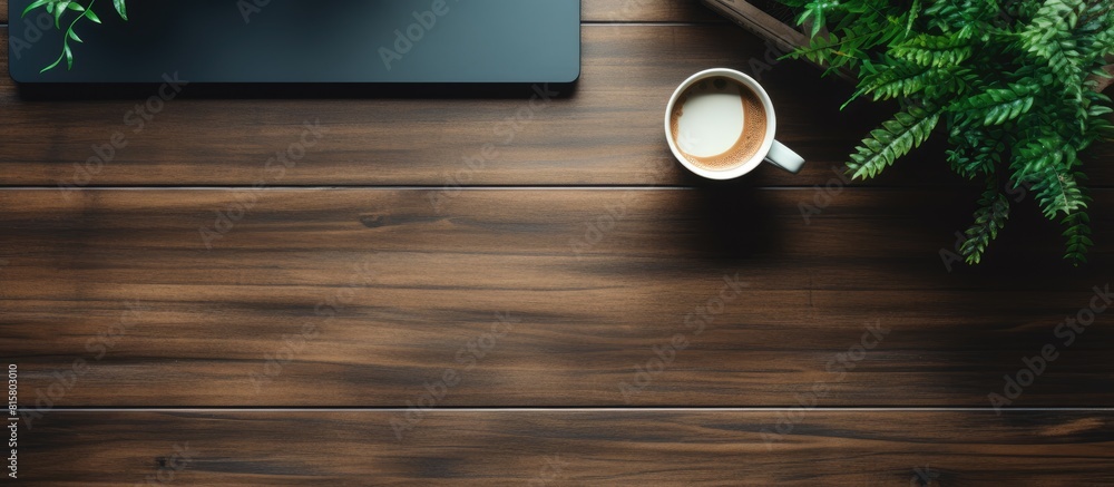 Poster the top down view of a black wooden office desk features a computer keyboard notepad plant and cup o