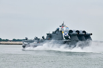 Hovercraft warship armed with armament sails into sea toward military target to attack and destroy...