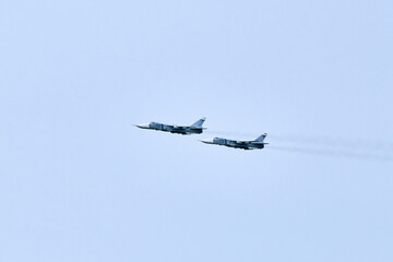 Two Russian military fighter planes armed with missiles flies in blue sky, airborne mission of...