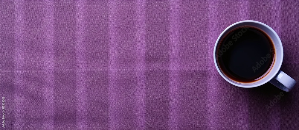 Poster top view of an empty mug cup placed on a fabric background with a purple check pattern creating a co