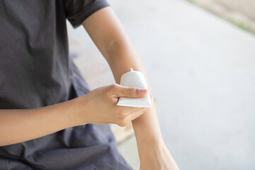 公園で日焼け止めを塗る女性