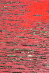 Detail of a wood plank with peeling red paint