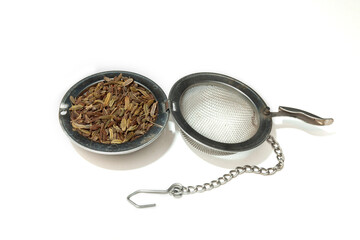 A tea infuser filled with herbal tea, a blend of fennel, anise, and caraway seeds.