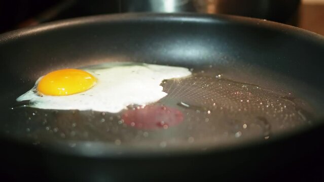 Cooking breakfast on hot pan frying an egg omelet