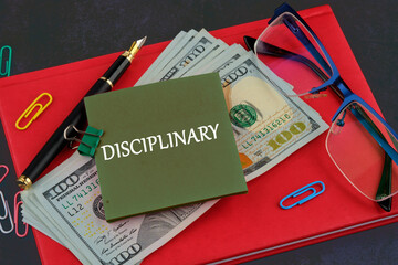 The concept of discipline or ethics word disciplinary written on a sticker on the background of a business notebook and dollars