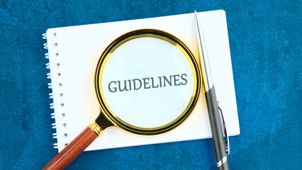 Text GUIDELINES through a magnifying glass on a blank sheet on a blue background