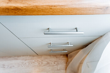 Rectangle wood cabinet with metal handles on beige hardwood counter