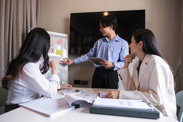 Naklejka premium Group of Asian businessmen discuss to plan analysis of company marketing strategy and brainstorm with report documents in office.