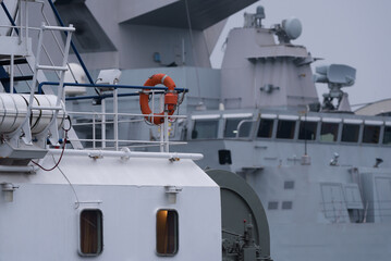 TUBOAT AND WARSHIP - Auxiliary ship and Italian Navy guided missile frigate moored at the seaport...