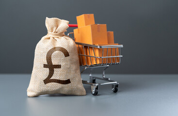 Shopping cart with boxes of goods and british pound sterling money bag. Profit from the sale of...