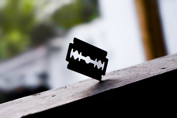 silhouette of a razor stuck in wood, a sharp razor with a blurred background