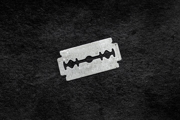 A sharp razor blade on a black background