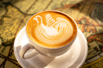 Close-up of a barista coffee with swan pattern in white cup on a table