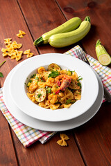 Piatto di farfalle condite con zucchine e gamberi, pasta italiana, cibo europeo 