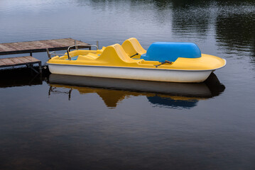 Fototapeta premium TOURISM - Yellow pedalo on the lake