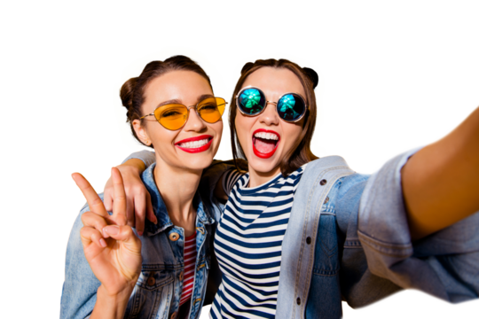 Two glad positive grinning lady stand in glasses spectacles street style stylish trendy cool casual denim jeans clothes isolated on yellow background in take picture on cellular make hollywood smile - Powered by Adobe