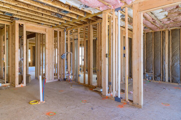 Under construction, new home is framing an unfinished wood frame with wooden trusses, posts, beams