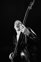Obraz premium rock musician plays bass guitar. Photo on a black background. Grain effect used
