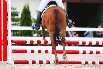 Rider jump to clear the obstacle. Horse Jumping, Equestrian Sports, Show Jumping. Chestnut horse on...