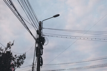 intertwined electric wires. A tangled electrical wires showcasing the complexities of the city's power supply system. telephone wires and wireless provider cables.