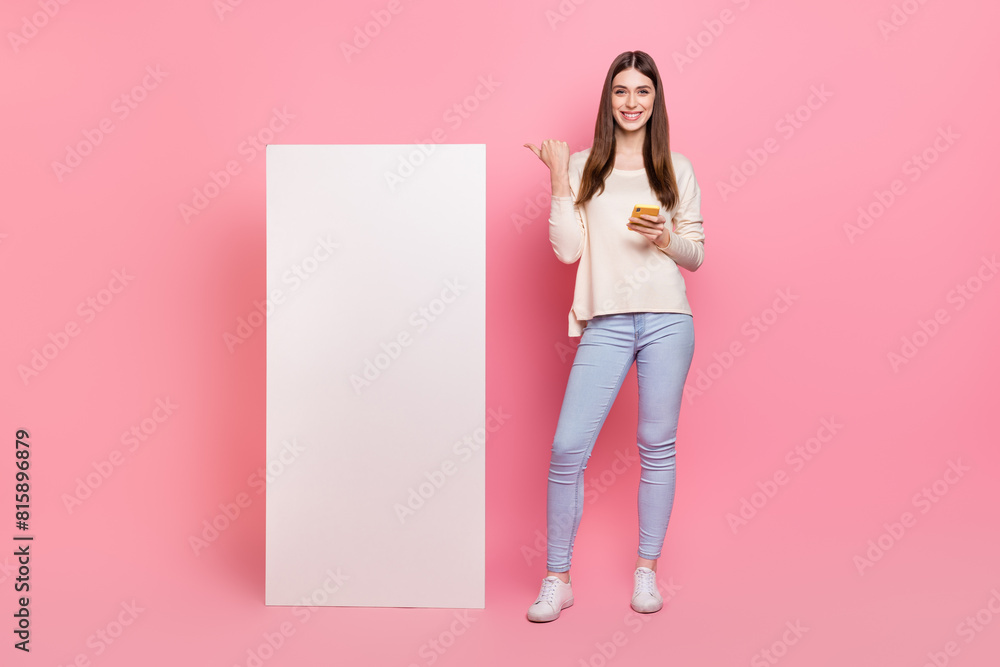 Poster full length body size view of beautiful trendy girl using device showing copy space ad isolated over