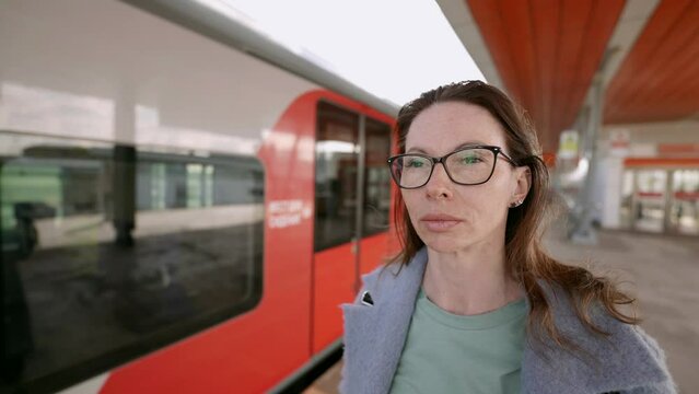 In the frame of public transport, the moment is captured when a stylish middle-aged woman wearing glasses plunges into her thoughts, creating an atmosphere of mystery.