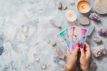 woman hands holding tarot cards, fortune telling, prophecy reading concept, top view esoteric magical layout with crystals, oracle and candles