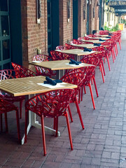Outside tables on a sidewalk set for customers at a cafe