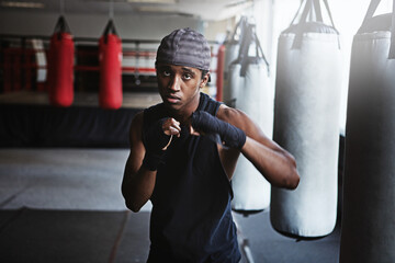 Fitness, punching and portrait of black man in MMA gym for boxing, challenge or competition...