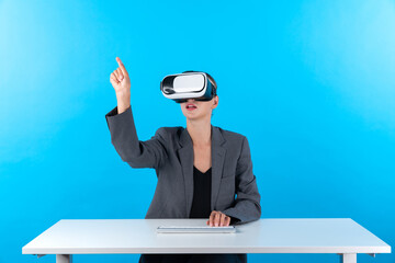 Smart manager wearing VR glasses while sitting at table with keyboard. Businesswoman pointing to...