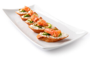 Deliziosi crostini conditi con crema di formaggio, zucchine e salmone affumicato, antipasti italiani 